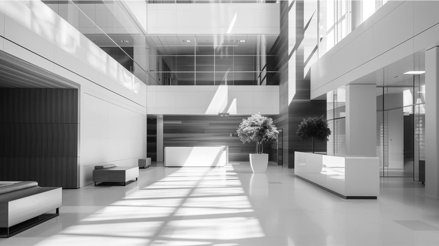 "Modern office lobby with large windows allowing natural light, minimalist furniture, and indoor plants."